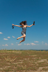Barefooted girl jumping with her shoes