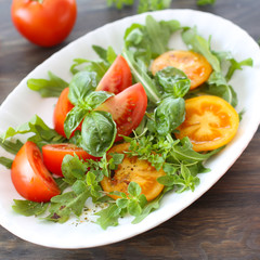 Red and yellow tomatoes with basil and rocket salad 