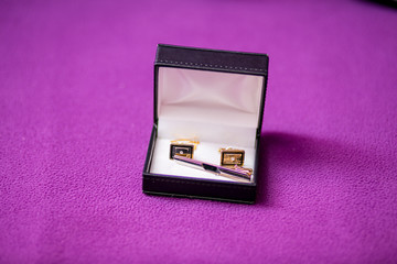 Men's cufflinks in the box on purple fabric