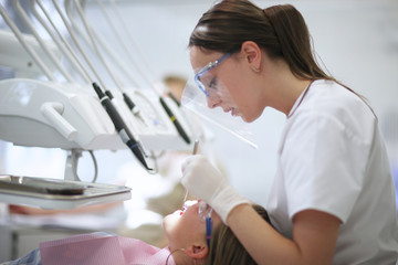 Profile of a female dentist at work - 101207619
