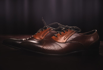 pair of brown leather shoes on a wooden floor