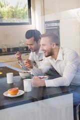 Smiling gay couple having breakfast