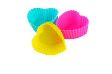 three multicolor silicone muffin pans on a white background