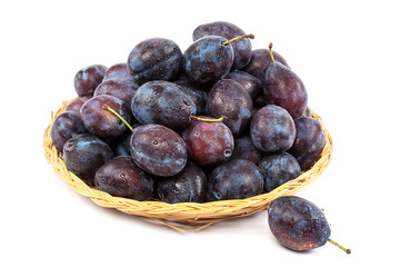 Fresh plums in a wicker dish