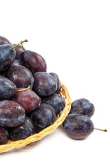 Fresh plums in a wicker dish.
