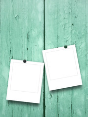 Close-up of two picture frames with pins on aqua painted wooden boards background