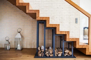 Fotobehang Trappen moderne oplossing om stapel hout onder de trap thuis op te bergen