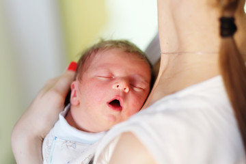 One day old newborn baby with mother