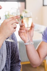 Smiling gay couple toasting with champagne 