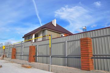 Fototapeta na wymiar Building a Metal and Concrete, Bricks Fence with Iron Bar Framework