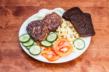 Plate with cutlets on wooden table