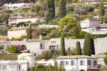 Fototapeta na wymiar Luxury wealthy stone villas in the hills of French Riviera with olive, palm trees,firs, agaves, cacti and colourful flowers on sunny summer day
