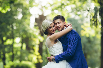 Beautiful wedding couple hugging in the park