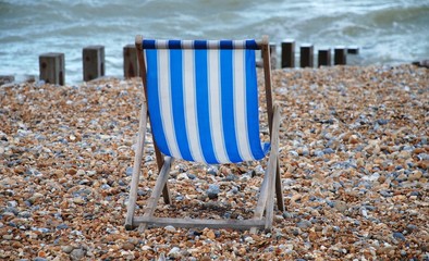 A striped deckchair on the shingle beach at St.Leonards-on-Sea in East Sussex, England.