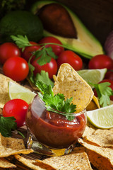 Unhealthy food: Mexican nachos with spicy tomato sauce and lime,