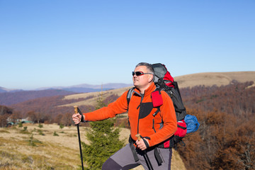 Man hiking in the mountains with a backpack and tent.