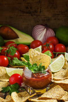 Unhealthy food: Mexican nachos with spicy tomato sauce and lime,