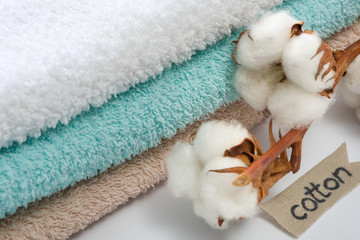Obraz na płótnie Canvas Stack of bath towels with cotton branch