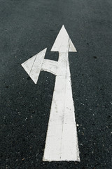 A close up on an arrow on pavement.