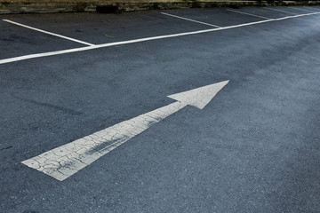 Arrow sign on asphalt surface