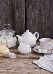 Fototapeta na wymiar Kitchen simple still life of tea, cup, white sugar lump in a bank and fresh homemade cakes