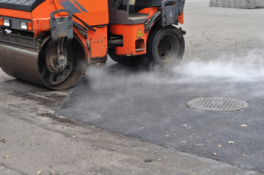 Road repair, compactor lays asphalt. Repair pavement and laying asphalt