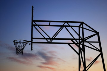 Fototapeta na wymiar Basketball hoop with metal construction against blue sky at sunset