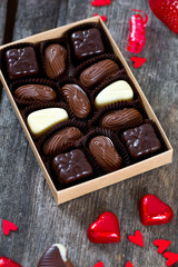 box of chocolate candies and hearts and ribbons around