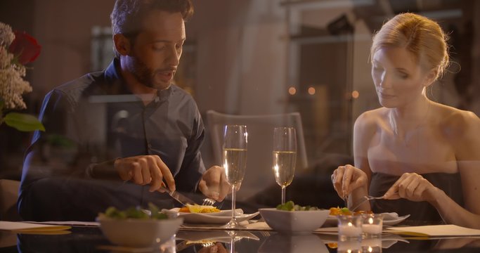 Beautiful elegant couple have dinner in the evening at restaurant in slow motion (in realtime at 60 fps)