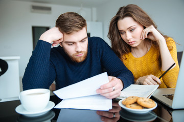 Couple reading their bills at home