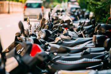 Naklejka premium Motorbike, motorcycle scooters parked in row in city street