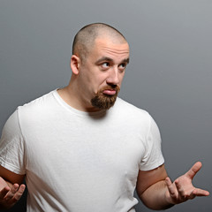 Portrait of a confused man against gray background