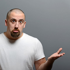 Portrait of a confused man against gray background