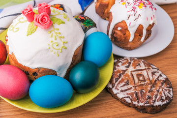 Traditional easter cake with glace icing  and colorful eggs on rustic table. Selective focus