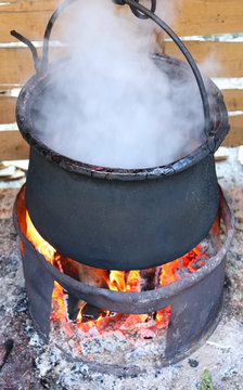 black pot with the fire and the  smoke during cooking