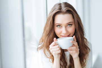 Attractive young woman drinking cofee at home