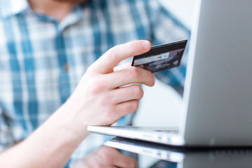 Man shopping online on laptop computer with credit card