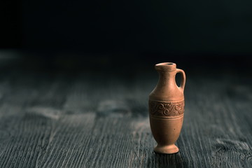 Small clay jug on a wooden table