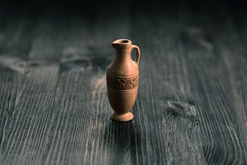 Small clay jug on a wooden table