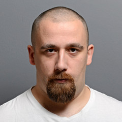 Obraz premium Portrait of a young man standing against gray background