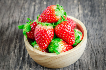 Red Strawberries in brown wooden bowl