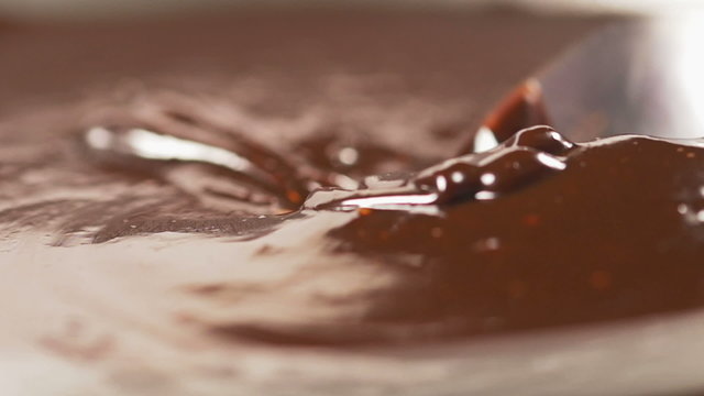 Mixing delicious melted chocolate with a spoon in slow motion