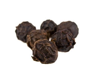 Black pepper corns on white background