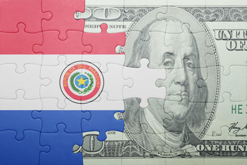 Fototapeta premium puzzle with the national flag of paraguay and dollar banknote