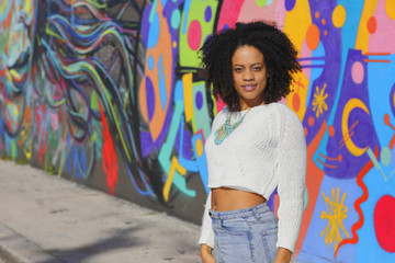 Fototapeta premium Woman posing in an urban setting with graffiti