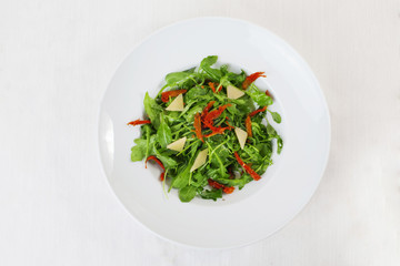 arugula salad dried tomatoes parmesan top circular plate white background isolated 