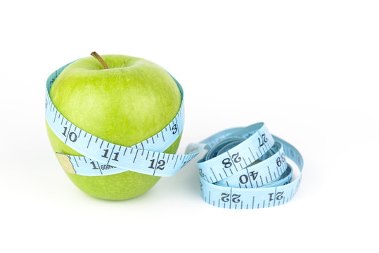 measurement tape and green apple, white background