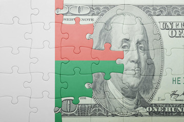 puzzle with the national flag of madagascar and dollar banknote