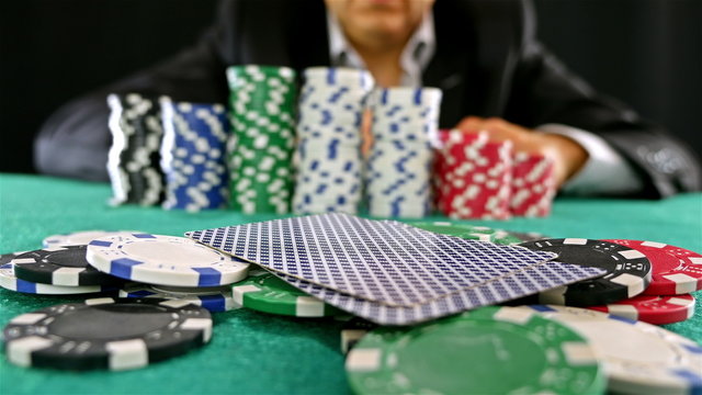 A gambler at a poker table doing fold