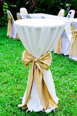 Wedding tabel in row decorated with golden color ribbon